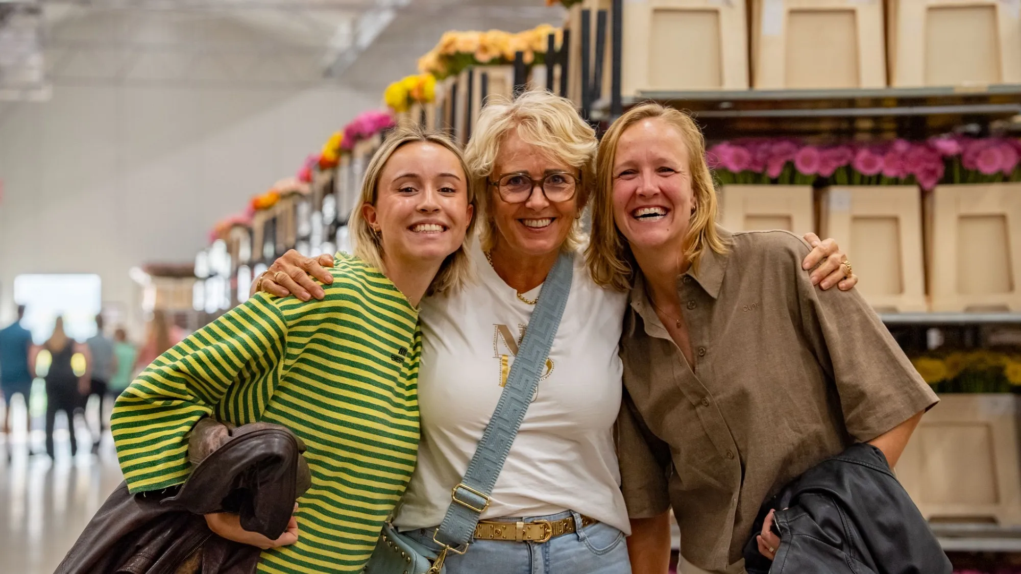 Eventfotografie bij EveryD Flowers: drie lachende bezoekers tussen de bloemen