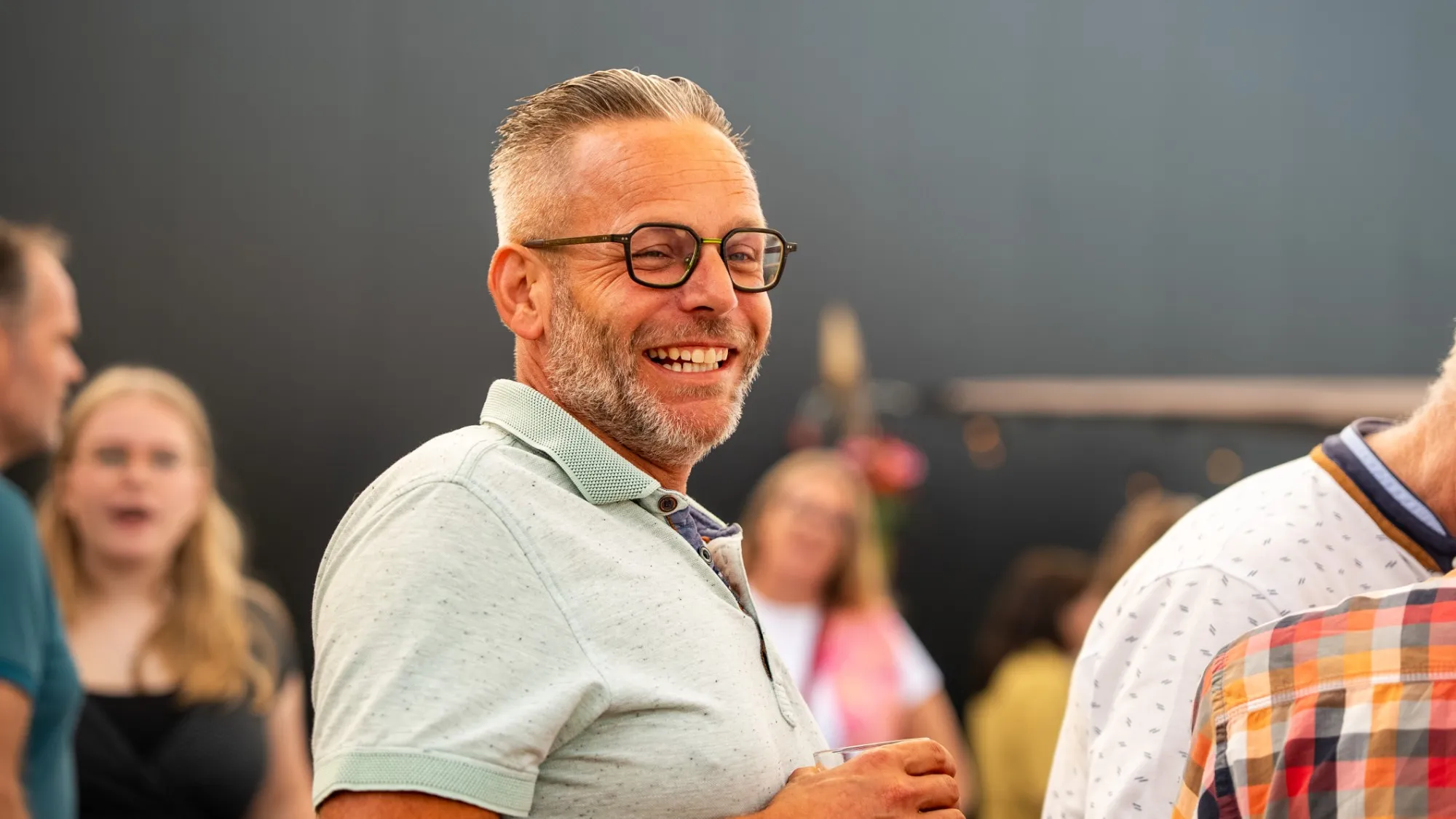 Eventfotografie bij EveryD Flowers: lachende gast met een drankje