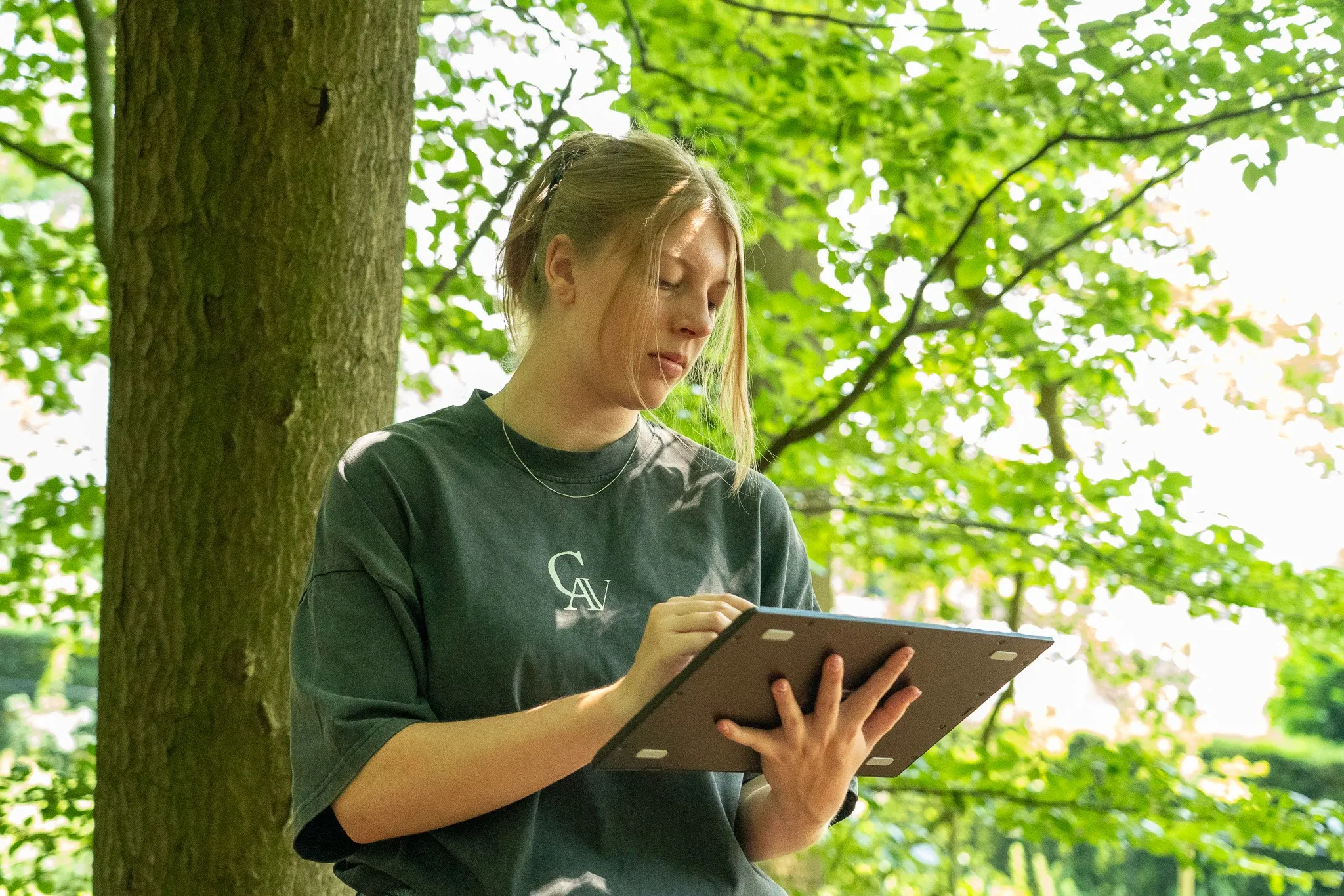 Ontwerper tekent op een tablet in het bos
